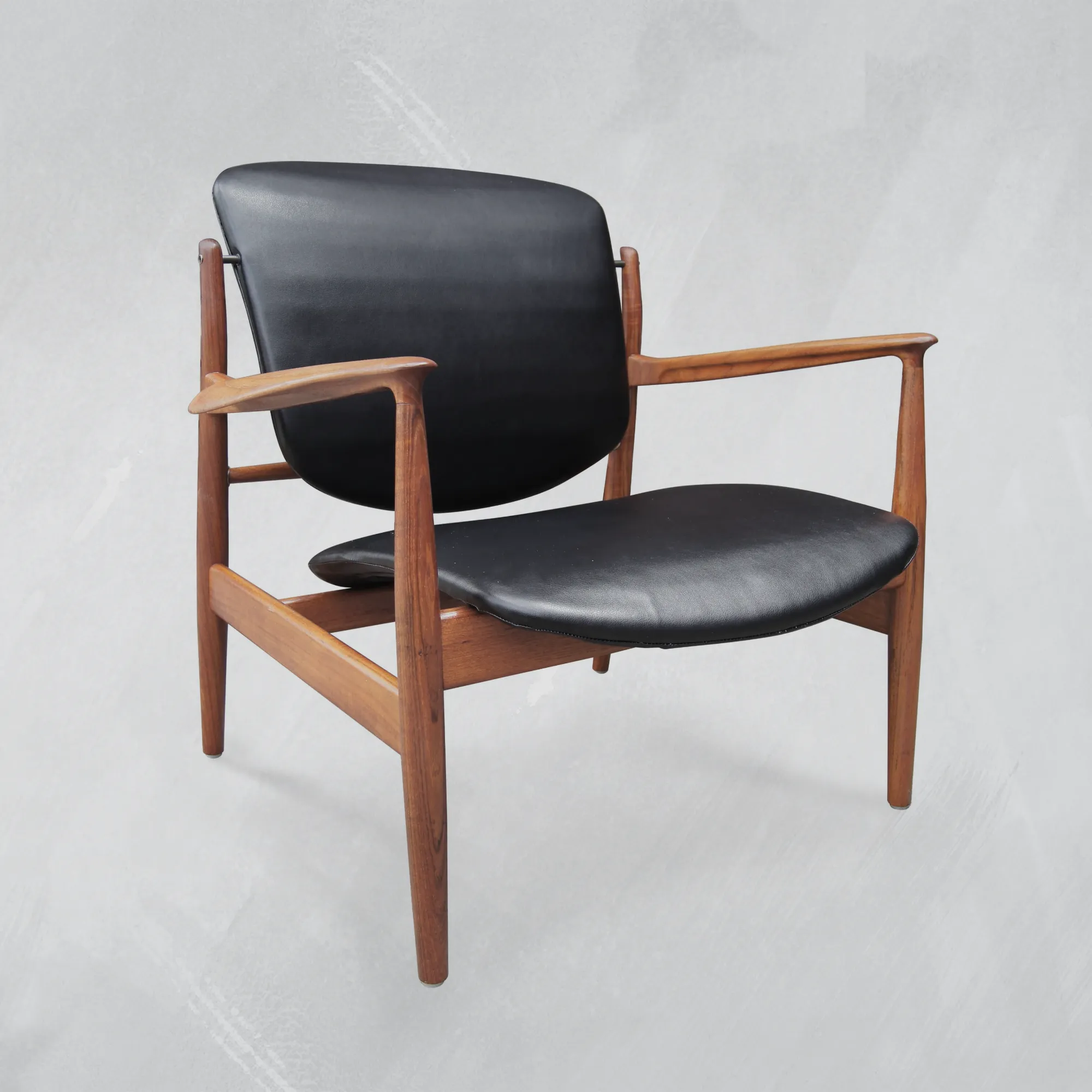 Finn Juhl France chair with black leather upholstery and oild walnut wood frame